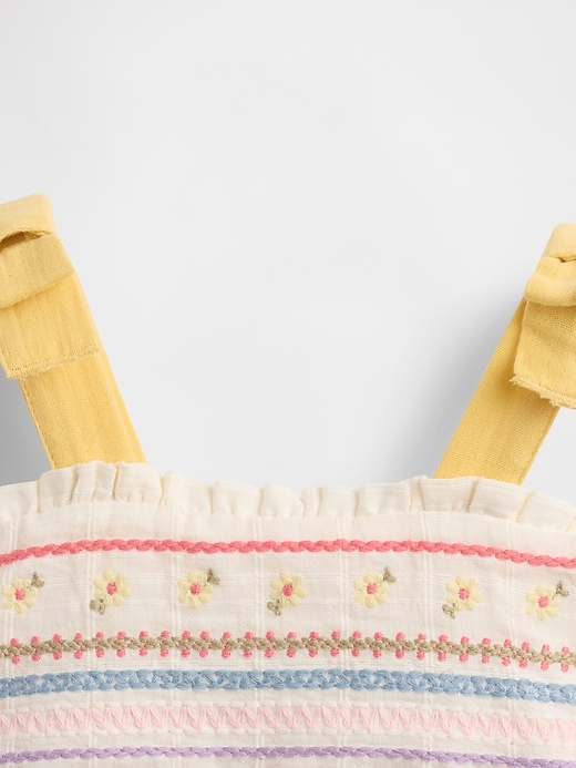 besticktes babykleid mit bindebändern an den schultern