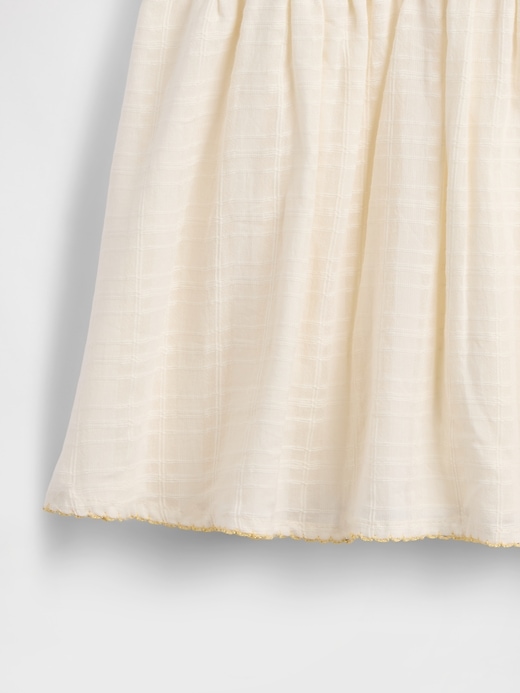 besticktes babykleid mit bindebändern an den schultern